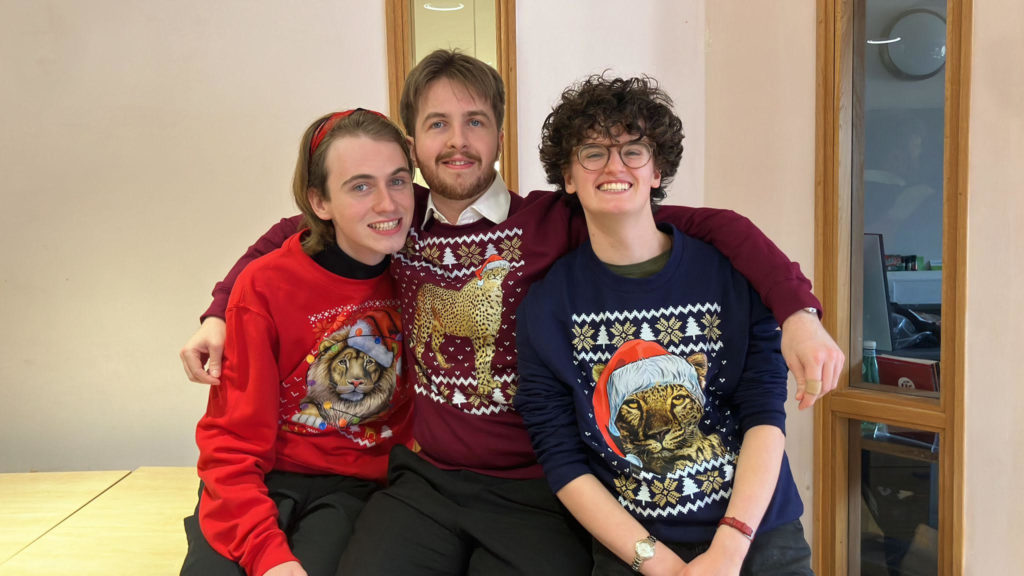 The Lion in Winter cast members in their costumes of coloured Christmas jumpers with cats on the front